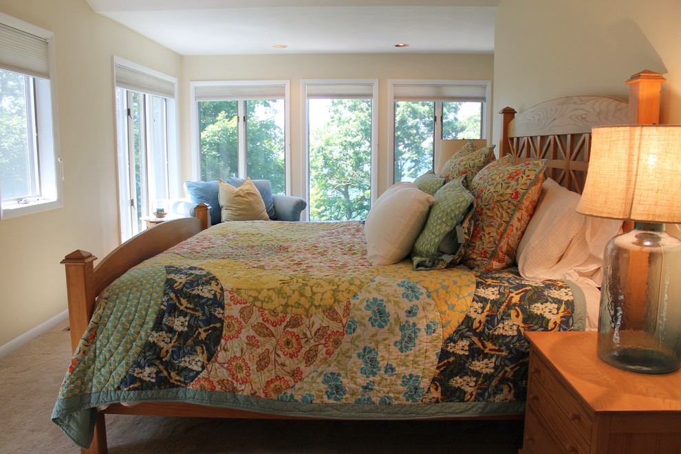 This is an example of a large beach style master bedroom in Grand Rapids with yellow walls and carpet.