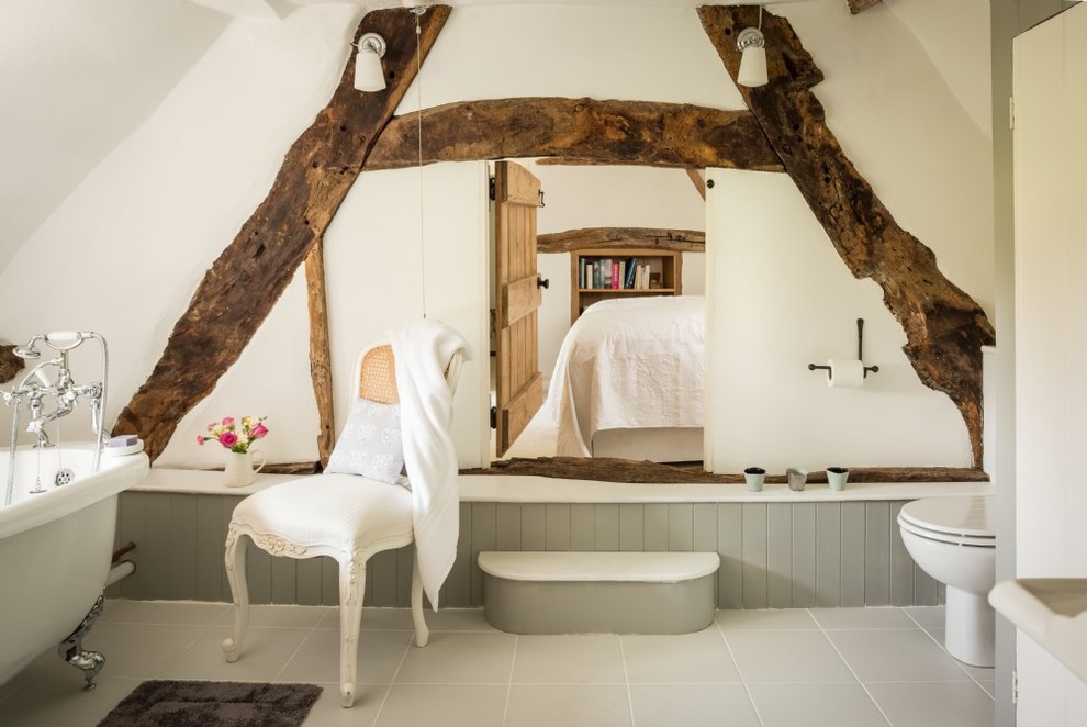Large country master bathroom in Wiltshire with a claw-foot tub, a shower/bathtub combo, a two-piece toilet, white walls, ceramic floors, a drop-in sink and grey floor.