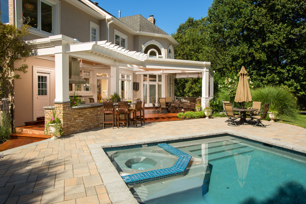Expansive traditional backyard rectangular lap pool in DC Metro with a hot tub and concrete pavers.