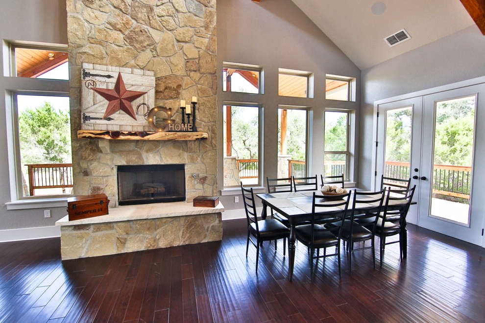 Great room - large rustic dark wood floor and brown floor great room idea in Austin with gray walls, a standard fireplace and a stone fireplace