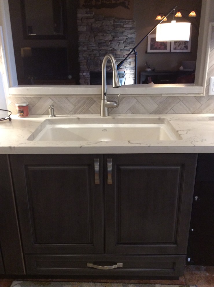 Example of a mid-sized transitional dark wood floor and brown floor eat-in kitchen design in Phoenix with a single-bowl sink, raised-panel cabinets, dark wood cabinets, onyx countertops, brown backsplash, ceramic backsplash, stainless steel appliances and an island