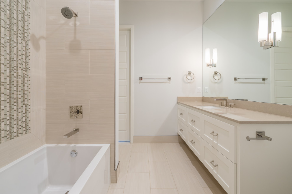 Modelo de cuarto de baño único y flotante contemporáneo de tamaño medio con armarios estilo shaker, puertas de armario blancas, bañera empotrada, combinación de ducha y bañera, sanitario de una pieza, baldosas y/o azulejos multicolor, baldosas y/o azulejos de porcelana, paredes blancas, suelo de baldosas de porcelana, lavabo bajoencimera, encimera de cuarzo compacto, suelo beige y encimeras beige