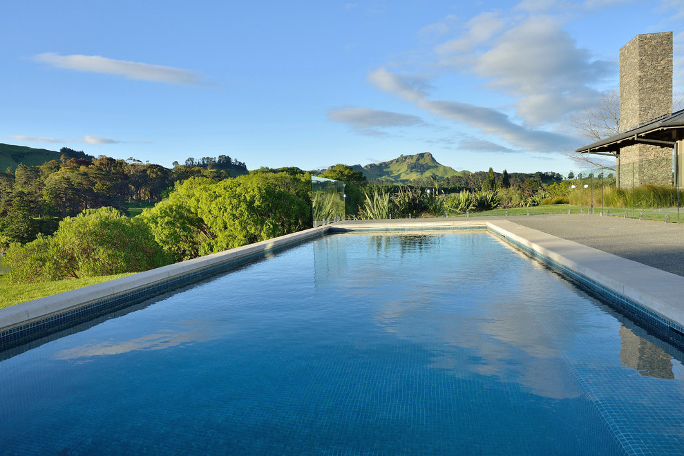 Country backyard rectangular natural pool in Napier-Hastings with natural stone pavers.