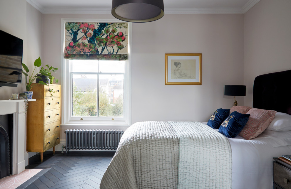 サリーにある広いヴィクトリアン調のおしゃれな主寝室 (ピンクの壁、濃色無垢フローリング、標準型暖炉、漆喰の暖炉まわり、黒い床) のインテリア
