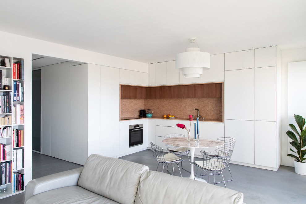 Design ideas for a contemporary l-shaped eat-in kitchen in Paris with an integrated sink, beaded inset cabinets, white cabinets, marble benchtops, pink splashback, marble splashback, panelled appliances, concrete floors, grey floor and pink benchtop.