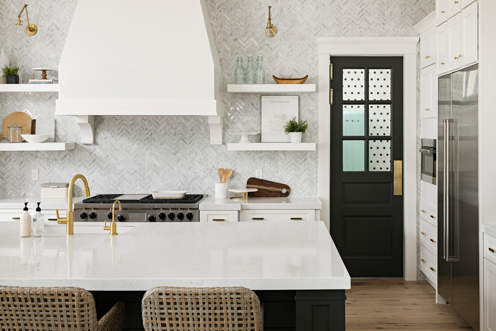 Huge transitional galley light wood floor and beige floor open concept kitchen photo in Phoenix with an undermount sink, shaker cabinets, white cabinets, quartz countertops, gray backsplash, marble backsplash, stainless steel appliances and an island
