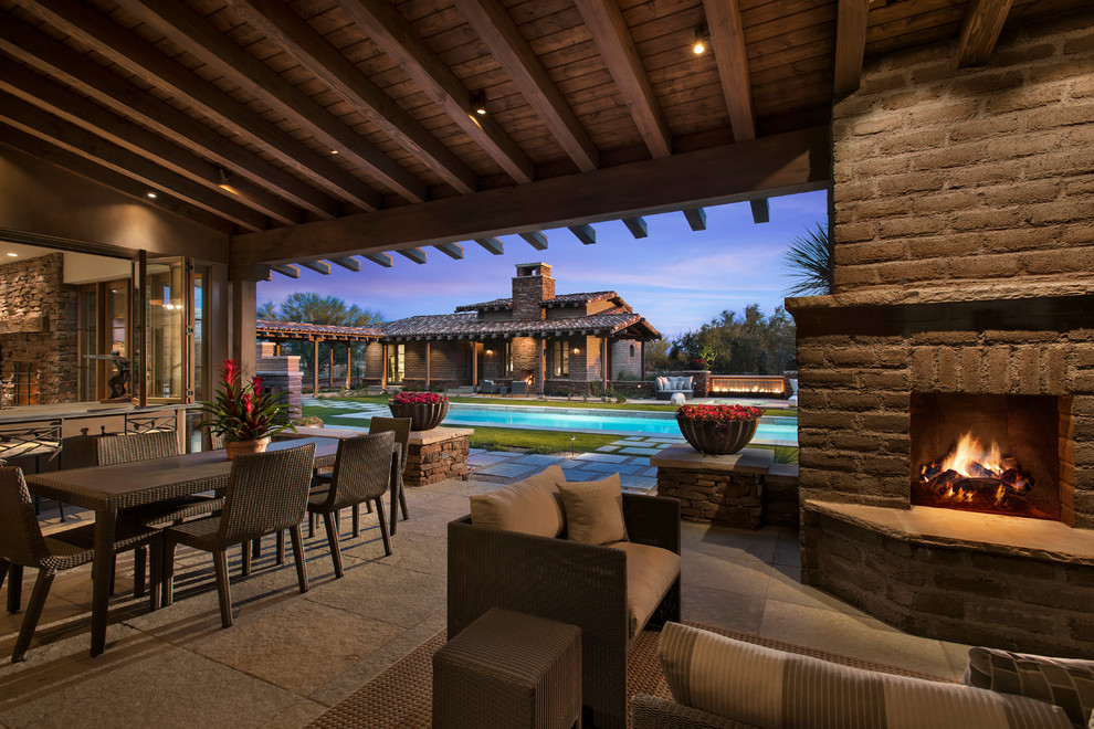 Large backyard patio in Phoenix with a fire feature and a roof extension.