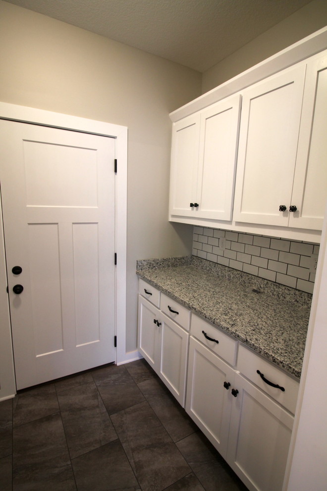 Design ideas for a small country galley dedicated laundry room in Kansas City with shaker cabinets, white cabinets, granite benchtops, porcelain floors, a side-by-side washer and dryer, grey floor and grey benchtop.