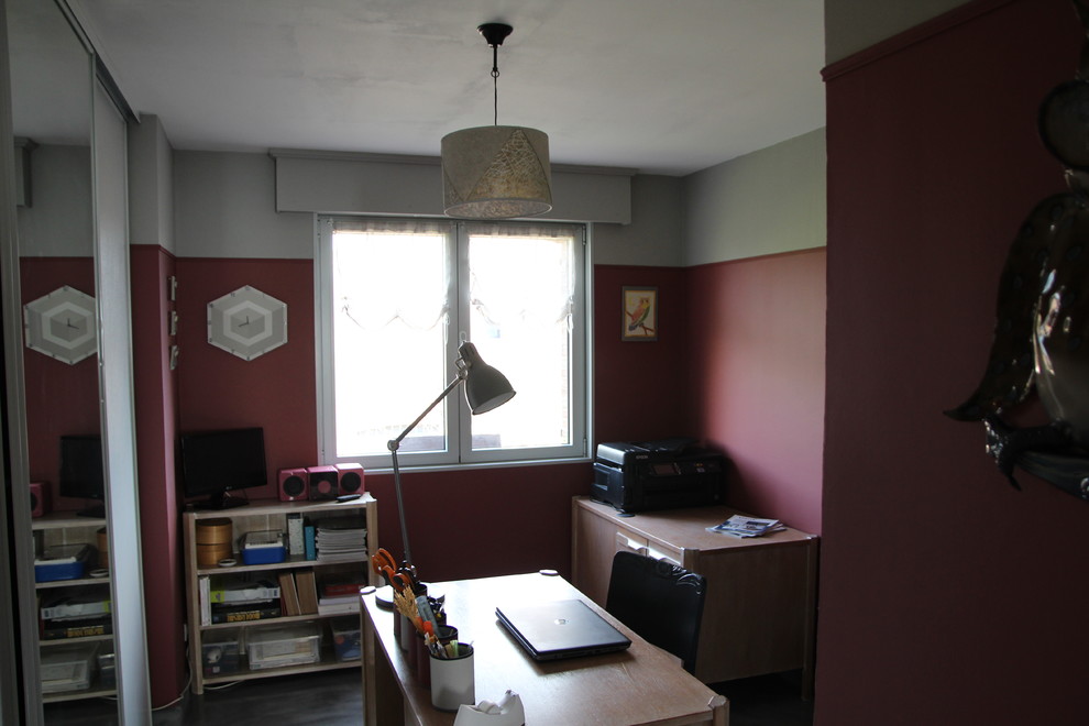 This is an example of a mid-sized contemporary study room in Lille with red walls, concrete floors, no fireplace, a freestanding desk and grey floor.