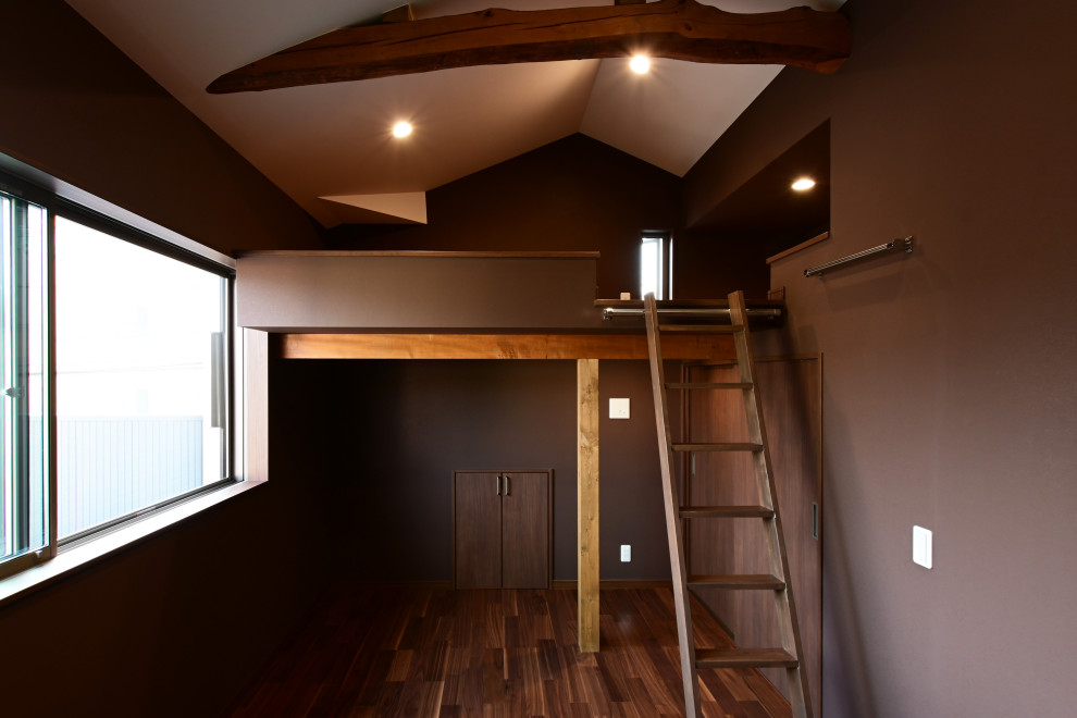 This is an example of a mid-sized asian loft-style bedroom in Other with beige walls, dark hardwood floors, no fireplace, brown floor, wallpaper and wallpaper.