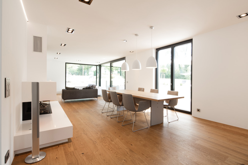 Inspiration for a large contemporary dining room in Stuttgart with white walls and medium hardwood floors.