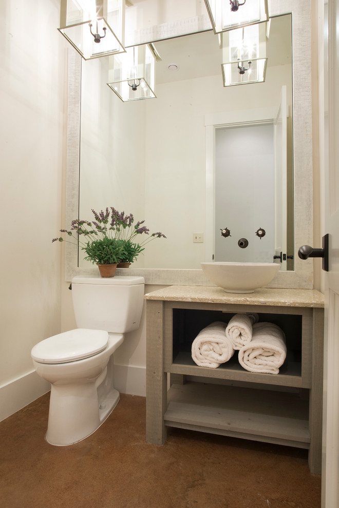 Design ideas for a mid-sized beach style 3/4 bathroom in Charleston with a vessel sink, open cabinets, grey cabinets, granite benchtops, a freestanding tub, a one-piece toilet, beige walls and concrete floors.