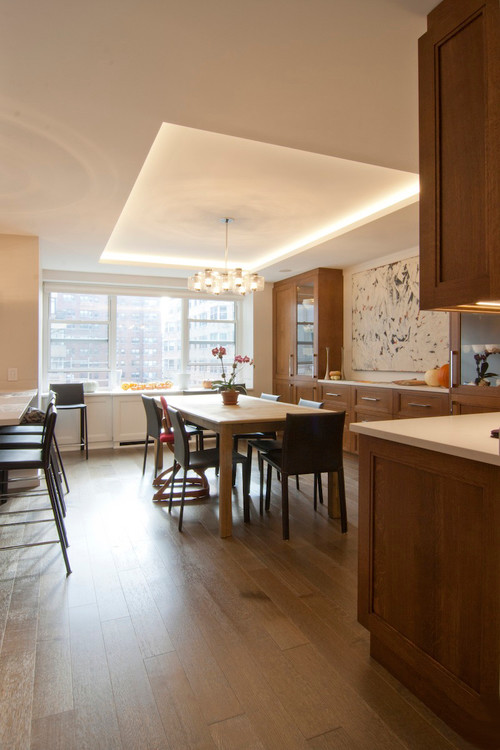 This is an example of a mid-sized contemporary kitchen/dining combo in New York with white walls, light hardwood floors and beige floor.