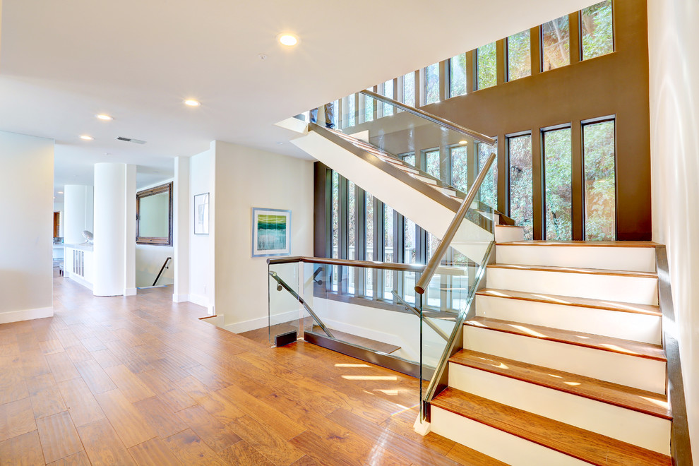 Design ideas for a large modern wood floating staircase in San Francisco with painted wood risers.