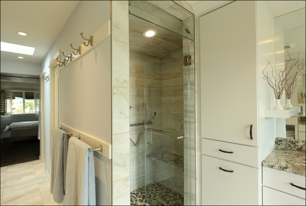 Design ideas for a mid-sized transitional master bathroom in Portland with flat-panel cabinets, white cabinets, a curbless shower, beige tile, blue walls, ceramic floors, a vessel sink, granite benchtops, beige floor, a hinged shower door and beige benchtops.