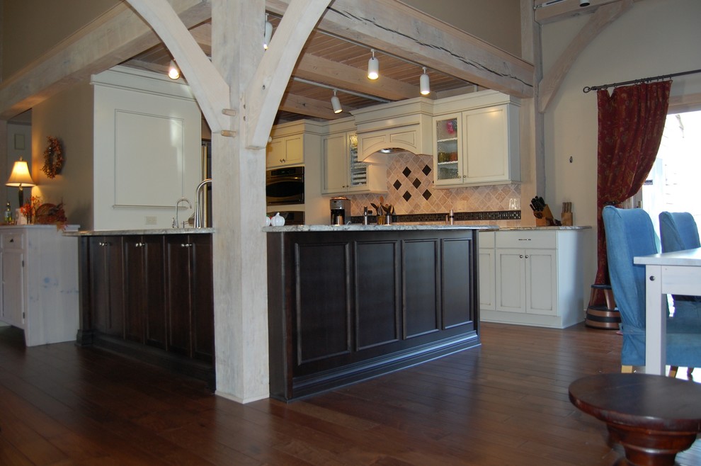 Inspiration for a mid-sized transitional u-shaped medium tone wood floor open concept kitchen remodel in Chicago with an undermount sink, flat-panel cabinets, dark wood cabinets, granite countertops, beige backsplash, stone tile backsplash, stainless steel appliances and a peninsula