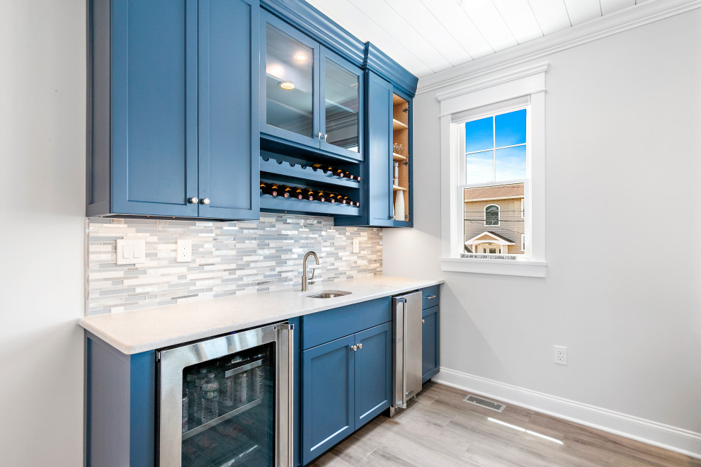 Maritime Hausbar in U-Form mit blauen Schränken, Küchenrückwand in Blau, Rückwand aus Stäbchenfliesen und weißer Arbeitsplatte in New York