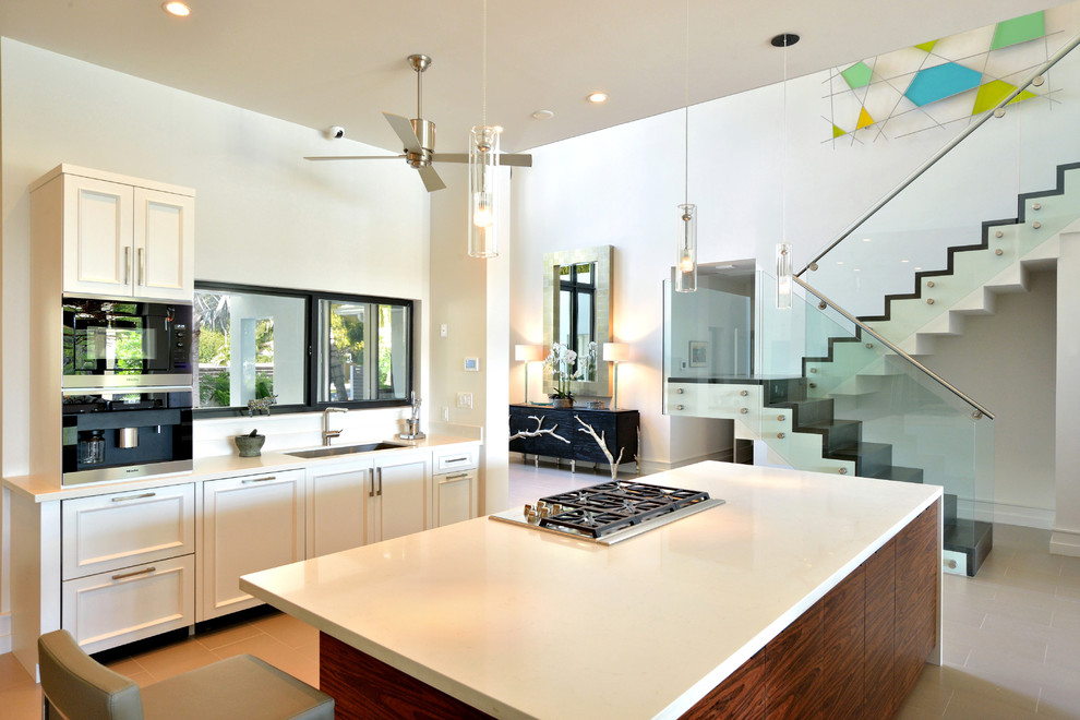 Design ideas for a mid-sized modern single-wall open plan kitchen in Miami with an undermount sink, shaker cabinets, white cabinets, quartz benchtops, white splashback, stainless steel appliances, ceramic floors, with island and beige floor.
