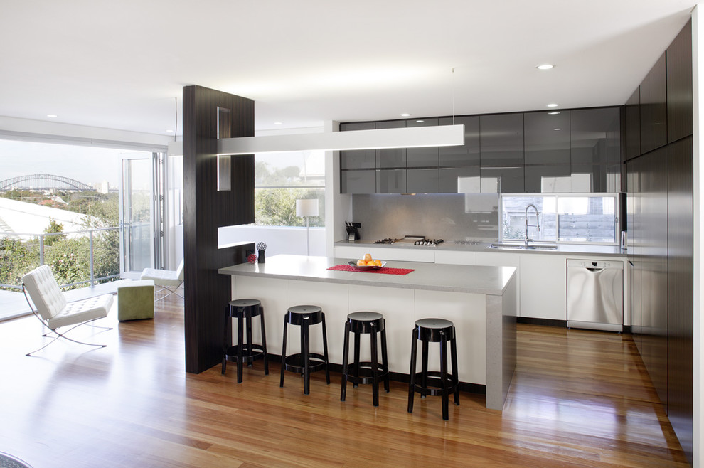 Trendy l-shaped kitchen photo in Sydney with an undermount sink, flat-panel cabinets, gray cabinets, gray backsplash, glass sheet backsplash and stainless steel appliances