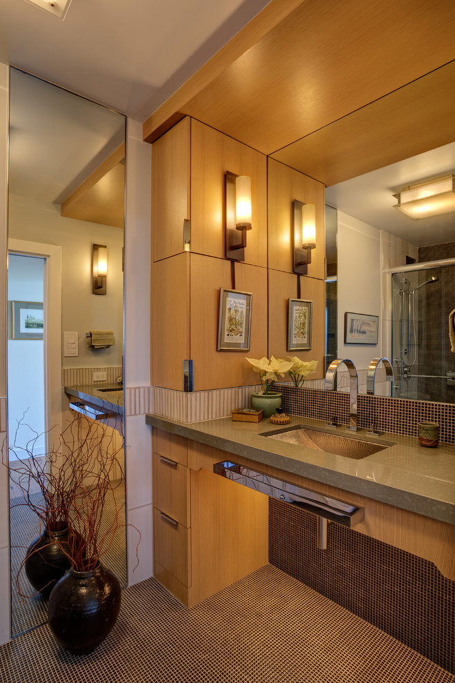 Photo of a small contemporary 3/4 bathroom in San Francisco with an undermount sink, flat-panel cabinets, medium wood cabinets, solid surface benchtops, brown tile, mosaic tile, an open shower, a wall-mount toilet, white walls, mosaic tile floors and brown floor.