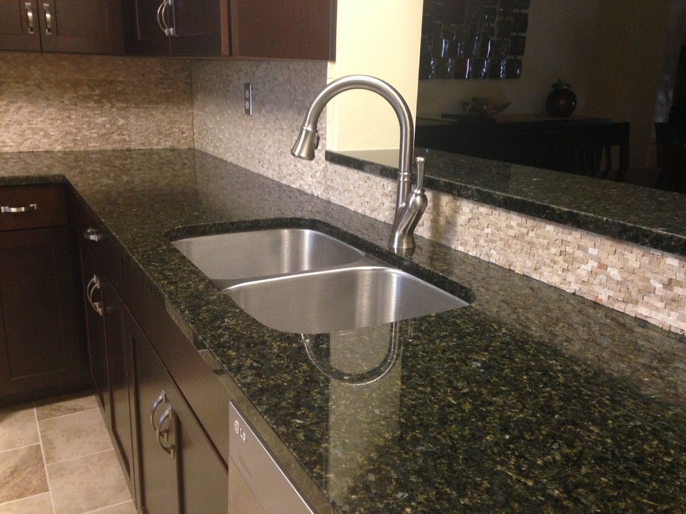 Inspiration for a mid-sized transitional l-shaped porcelain tile enclosed kitchen remodel with an undermount sink, shaker cabinets, dark wood cabinets, granite countertops, beige backsplash, stone tile backsplash, stainless steel appliances and an island