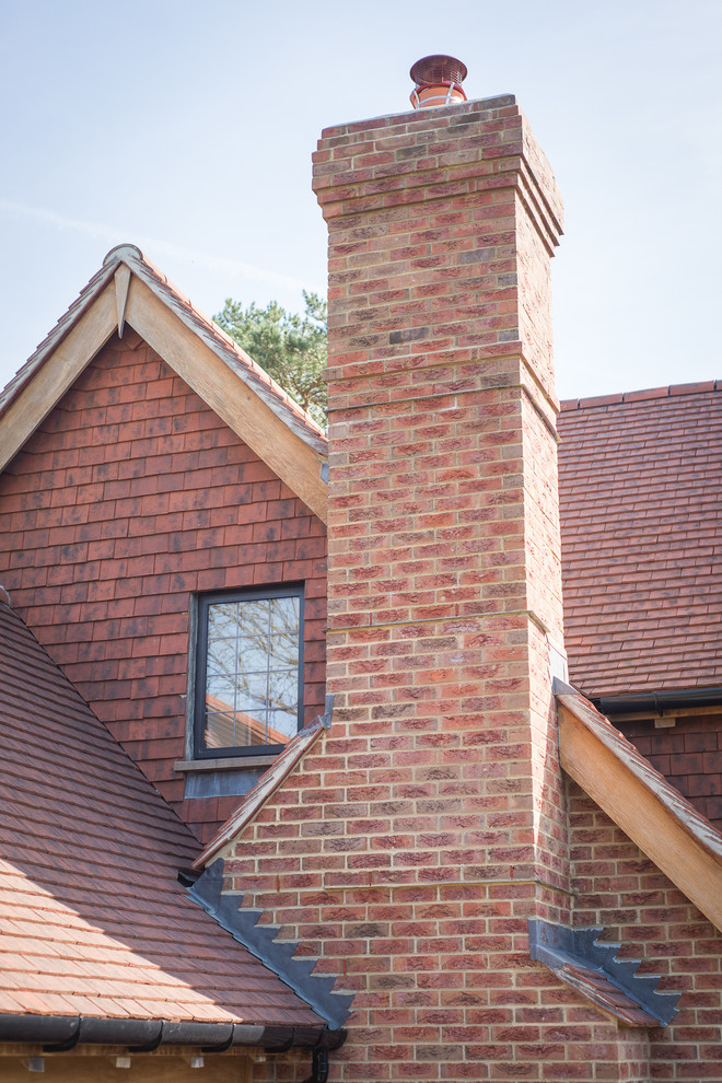 This is an example of a large country two-storey brick house exterior in Sussex with a gable roof and a tile roof.
