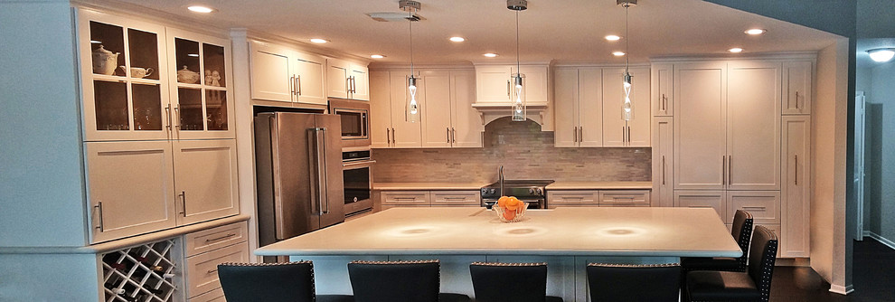 Example of a large transitional l-shaped medium tone wood floor and brown floor open concept kitchen design in Houston with a farmhouse sink, shaker cabinets, white cabinets, quartz countertops, white backsplash, marble backsplash, stainless steel appliances and an island