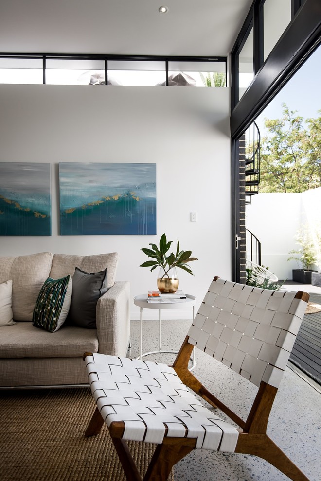 This is an example of a small contemporary living room in Perth with white walls, concrete floors and a freestanding tv.