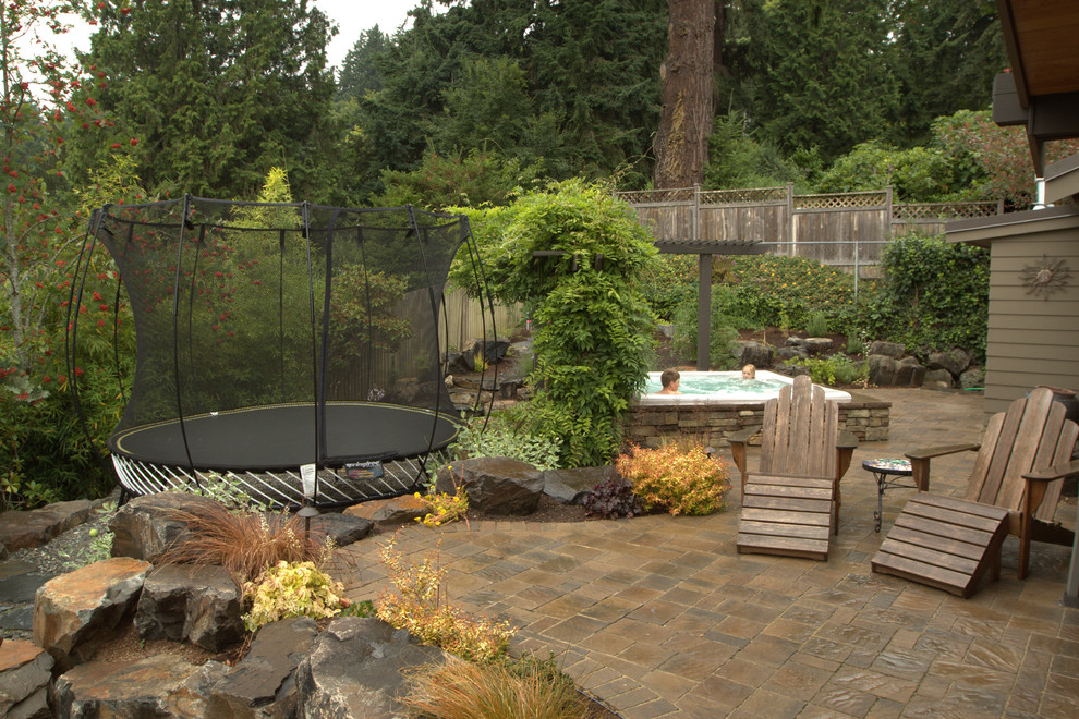 Large traditional backyard patio in Seattle with natural stone pavers and a gazebo/cabana.