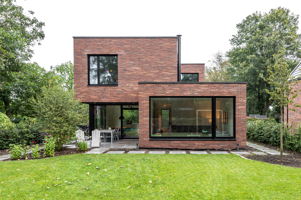 Стильный дизайн: большой, двухэтажный дом в современном стиле с облицовкой из камня и плоской крышей - последний тренд