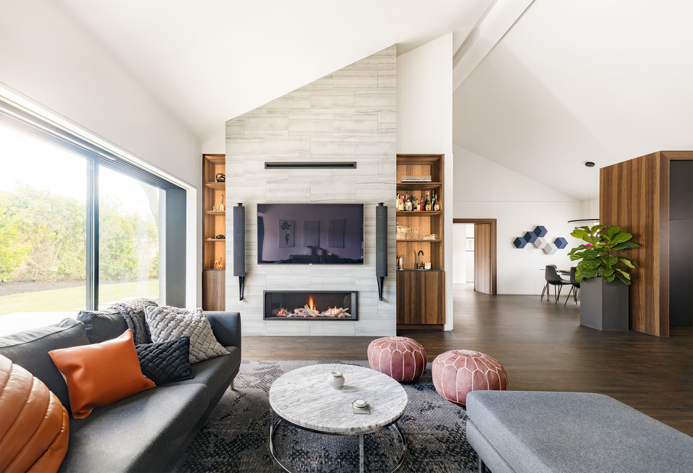 Mid-sized trendy open concept dark wood floor and brown floor living room photo in Boston with a bar, white walls, a standard fireplace, a stone fireplace and a wall-mounted tv