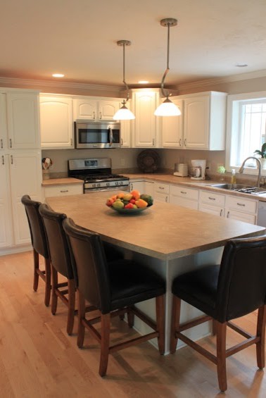 Inspiration for a large modern galley light wood floor eat-in kitchen remodel with a drop-in sink, raised-panel cabinets, white cabinets, laminate countertops, stainless steel appliances and an island