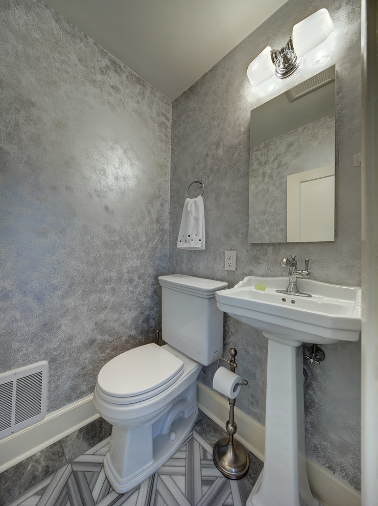Inspiration for a small transitional powder room in New York with a two-piece toilet, grey walls, marble floors, a pedestal sink and gray tile.