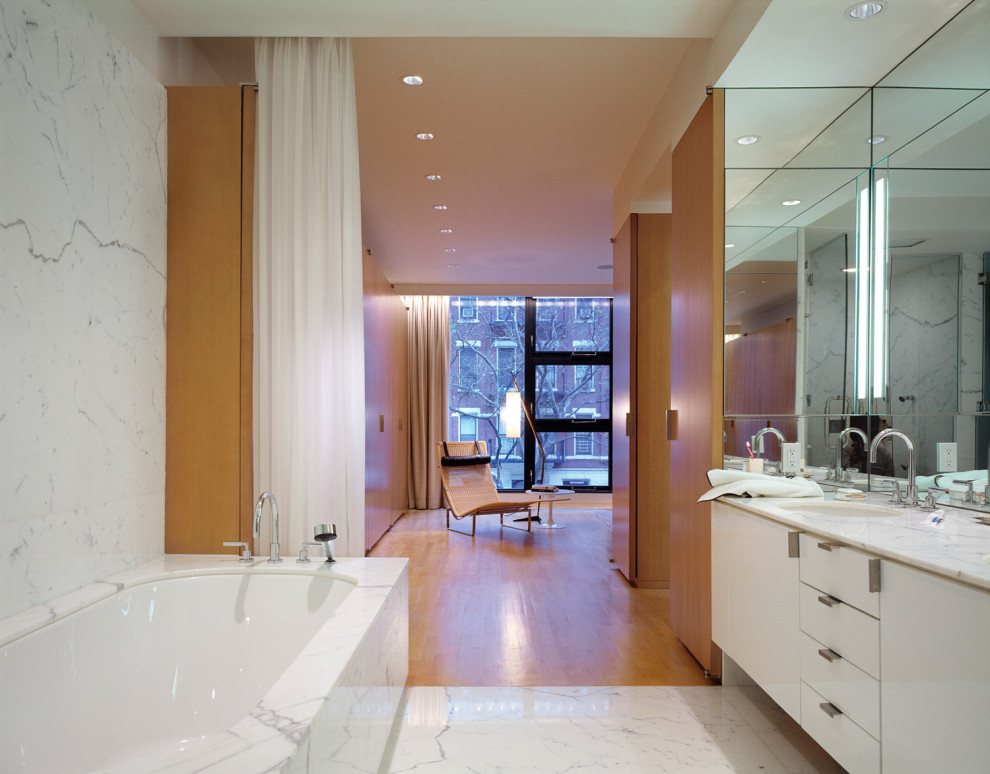 Inspiration for a large midcentury master bathroom in New York with flat-panel cabinets, white cabinets, a corner tub, an alcove shower, white tile, marble, white walls, marble floors, an undermount sink, granite benchtops, yellow floor, a hinged shower door, yellow benchtops, a double vanity and a built-in vanity.