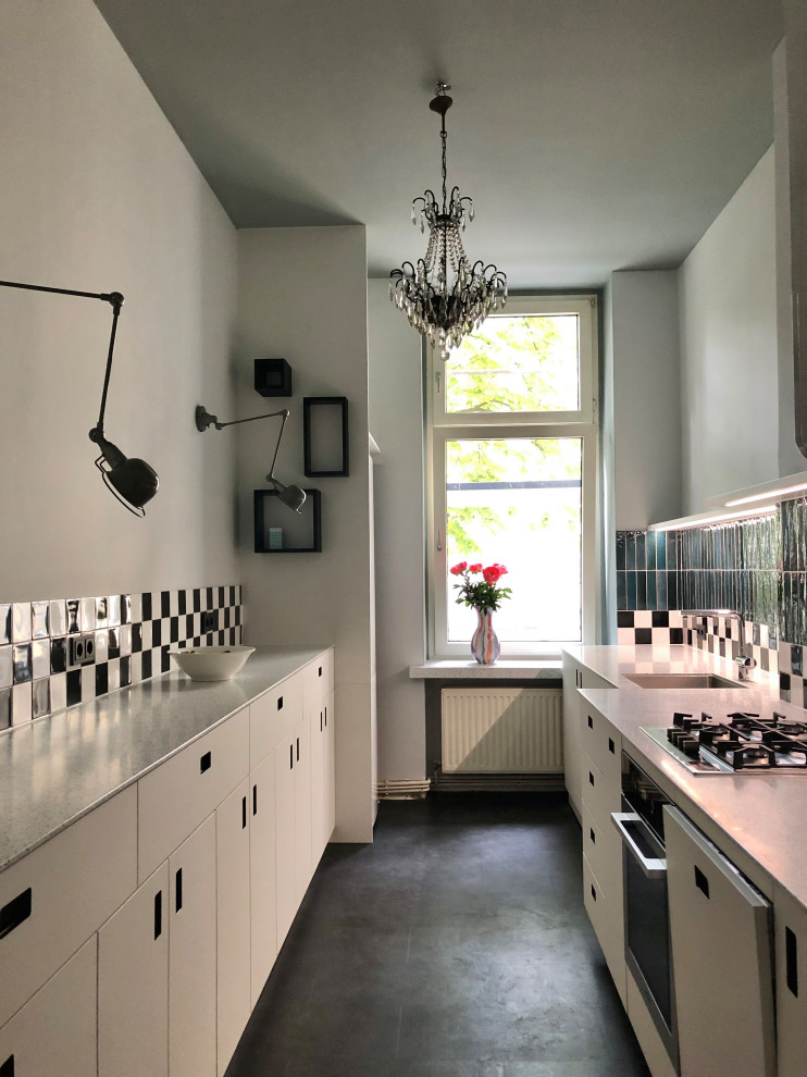 ベルリンにある中くらいなエクレクティックスタイルのおしゃれなキッチン (アンダーカウンターシンク、フラットパネル扉のキャビネット、白いキャビネット、人工大理石カウンター、黒い床) の写真