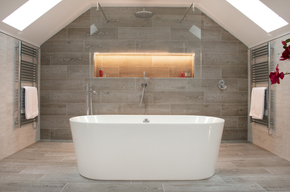 Inspiration for a large contemporary master bathroom in Gloucestershire with flat-panel cabinets, white cabinets, a freestanding tub, an open shower, a wall-mount toilet, porcelain tile, porcelain floors, a wall-mount sink, an open shower, a niche, a single vanity and a floating vanity.