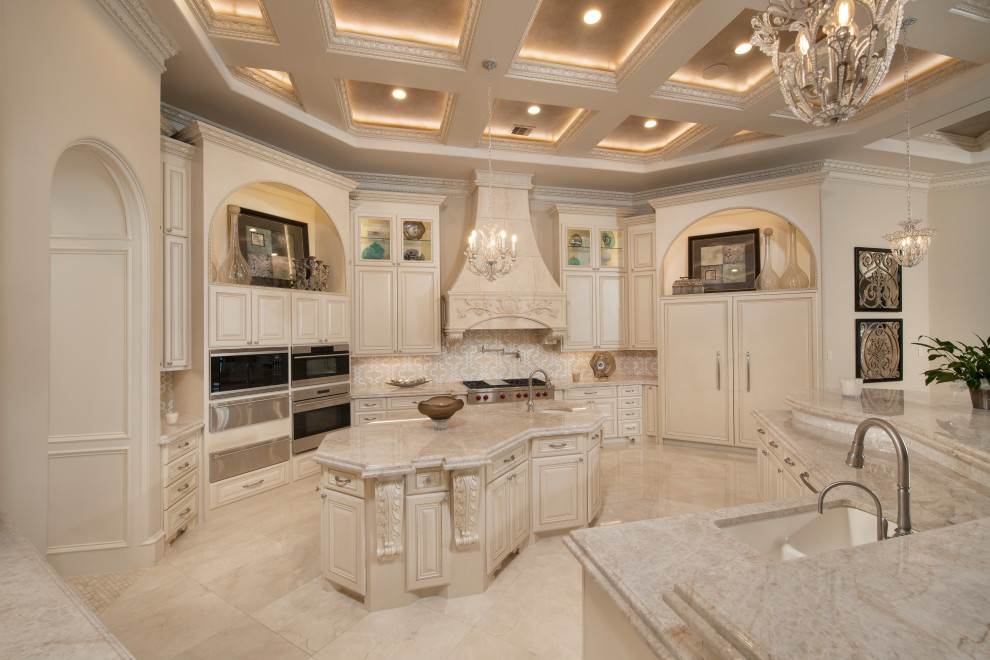 This is an example of a large mediterranean kitchen in Houston with an undermount sink, raised-panel cabinets, beige cabinets, granite benchtops, multi-coloured splashback, stone tile splashback, panelled appliances, marble floors, beige floor, beige benchtop and coffered.
