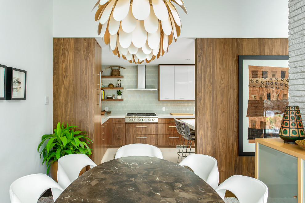 Photo of a large contemporary u-shaped kitchen/diner in Dallas with a submerged sink, flat-panel cabinets, medium wood cabinets, engineered stone countertops, blue splashback, glass tiled splashback, stainless steel appliances, porcelain flooring, a breakfast bar, black floors and white worktops.