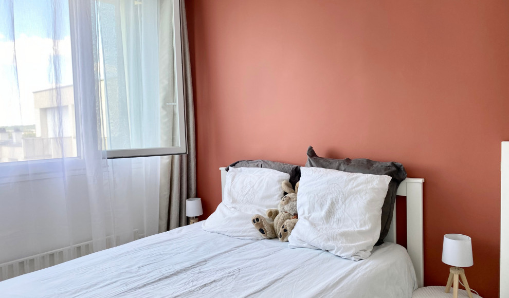 Kleines Skandinavisches Schlafzimmer ohne Kamin mit oranger Wandfarbe, Laminat und beigem Boden in Paris