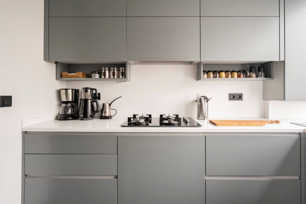 This is an example of a small modern l-shaped enclosed kitchen in London with a double-bowl sink, flat-panel cabinets, grey cabinets, engineered stone countertops, ceramic flooring, grey floors and white worktops.