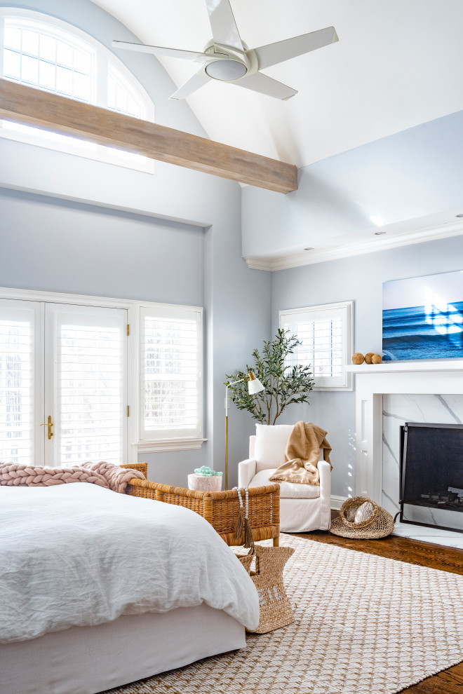 Réalisation d'une petite chambre parentale marine avec un mur bleu, une cheminée standard, un manteau de cheminée en carrelage, un sol marron, poutres apparentes et parquet foncé.
