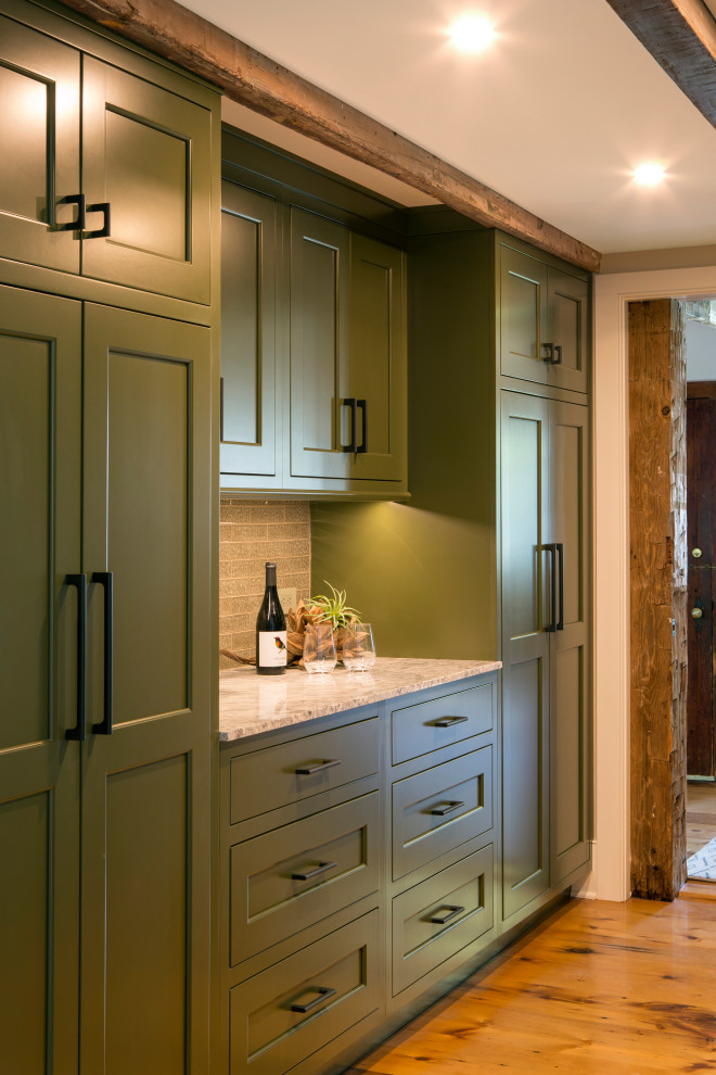 Small country home bar in New York with recessed-panel cabinets, green cabinets, marble benchtops, grey splashback, glass tile splashback, light hardwood floors, beige floor and multi-coloured benchtop.