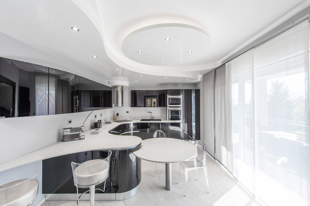 Contemporary u-shaped eat-in kitchen in Turin with a double-bowl sink, flat-panel cabinets, black cabinets, white splashback, stainless steel appliances, a peninsula, white floor and white benchtop.