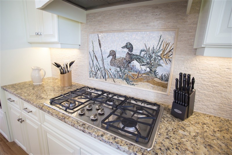 Open concept kitchen - mid-sized transitional l-shaped medium tone wood floor open concept kitchen idea with an undermount sink, raised-panel cabinets, beige cabinets, granite countertops, beige backsplash, stone tile backsplash, stainless steel appliances and an island