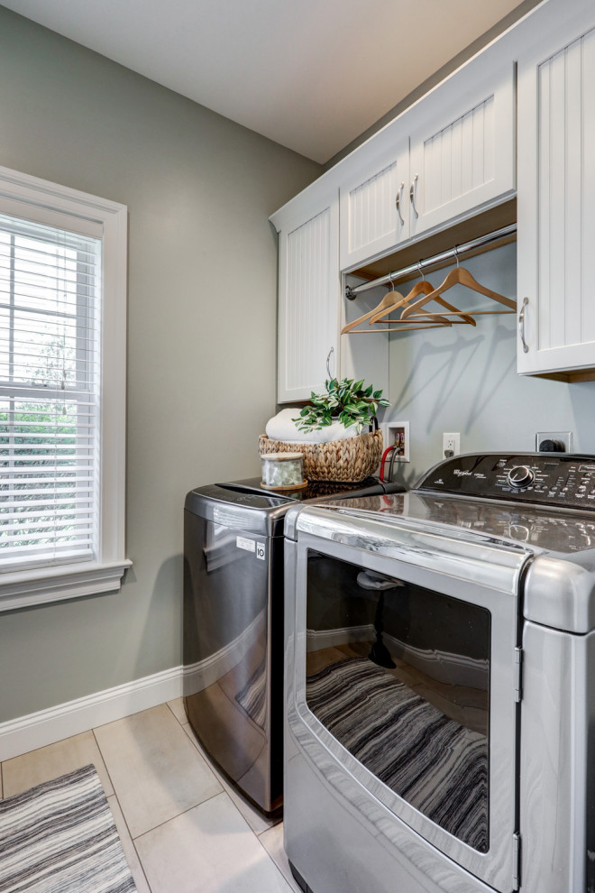 Small traditional single-wall dedicated laundry room in Other with louvered cabinets, white cabinets, grey walls, ceramic floors, a side-by-side washer and dryer and beige floor.