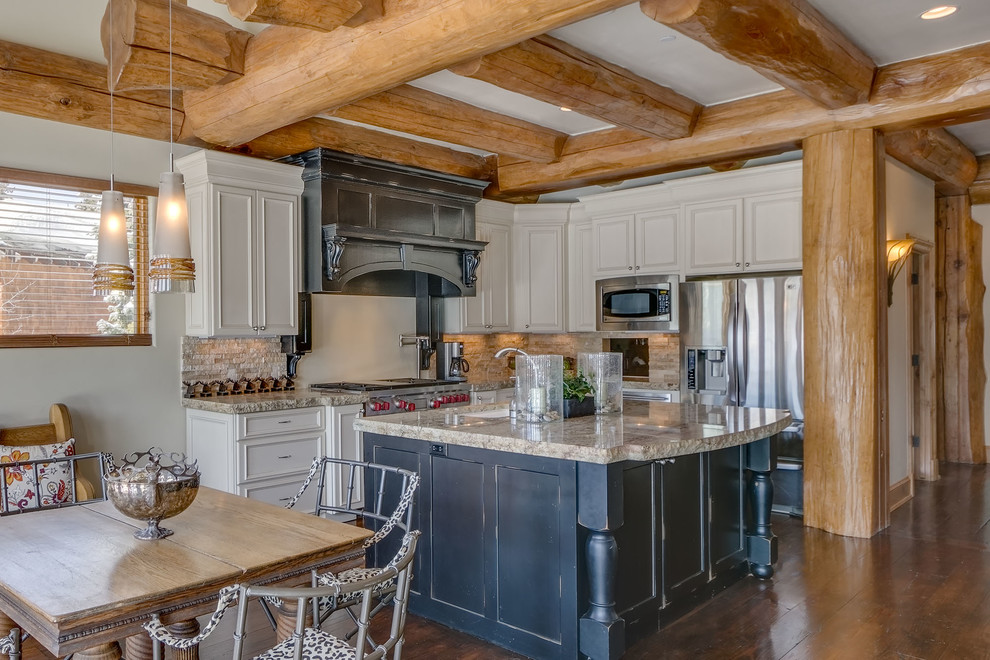 Eat-in kitchen - mid-sized rustic l-shaped medium tone wood floor and brown floor eat-in kitchen idea with an undermount sink, beaded inset cabinets, white cabinets, granite countertops, beige backsplash, stone tile backsplash, stainless steel appliances and an island