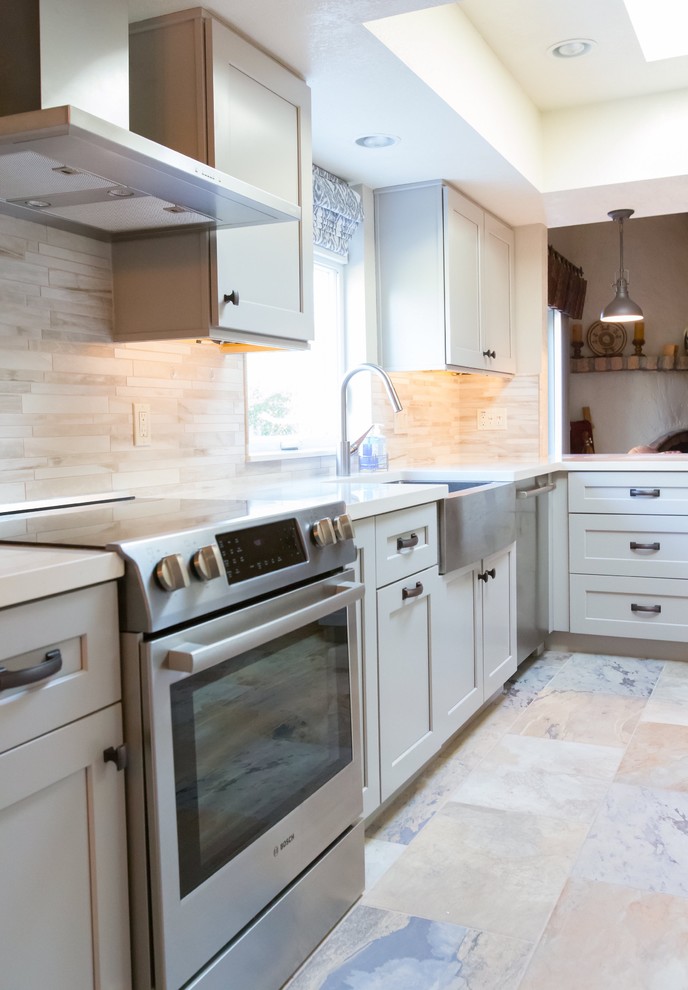 Inspiration for a mid-sized transitional u-shaped porcelain tile kitchen remodel in Phoenix with a farmhouse sink, shaker cabinets, gray cabinets, quartz countertops, gray backsplash, porcelain backsplash, stainless steel appliances and a peninsula