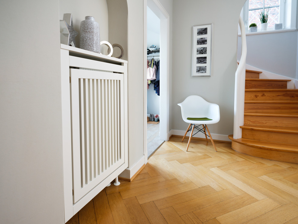 This is an example of a small contemporary hallway in Hamburg with grey walls, medium hardwood floors and brown floor.