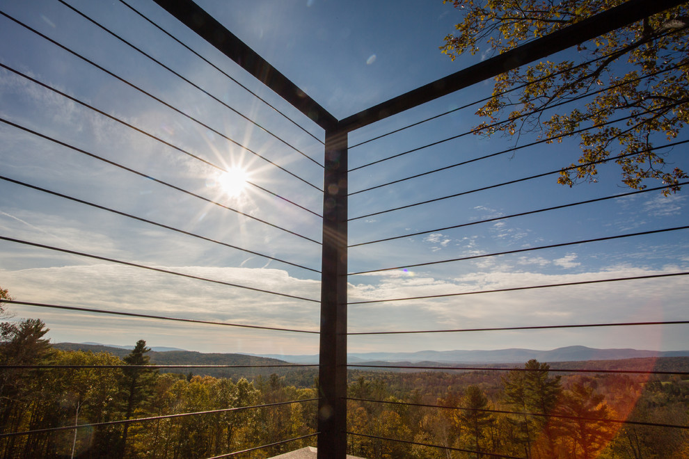 Example of a large mountain style backyard deck design in New York with no cover
