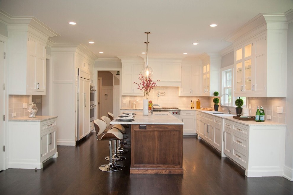 Eat-in kitchen - large transitional u-shaped dark wood floor eat-in kitchen idea in New York with an undermount sink, recessed-panel cabinets, white cabinets, marble countertops, white backsplash, glass tile backsplash, stainless steel appliances and an island